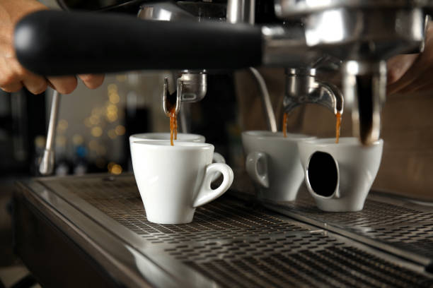 istock Barista making espresso using professional coffee machine, closeup 1395304477