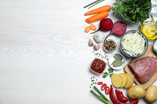 Fresh borscht ingredients on white wooden table, flat lay. Space for text