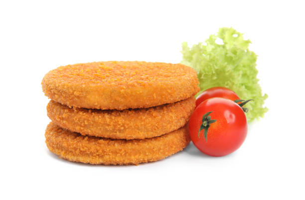 istock Uncooked breaded cutlets, tomatoes and lettuce on white background. Freshly frozen semi-finished product 1395305081