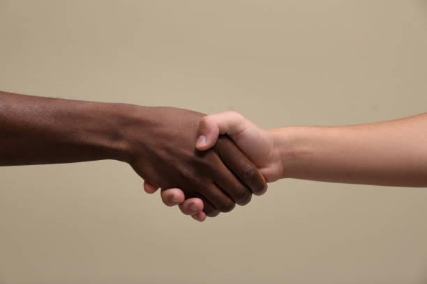 istock Men shaking hands on beige background, closeup 1395305956
