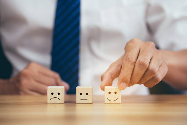 istock Satisfaction concept, Businessman choose smiley face a on wood cube. 1395306050