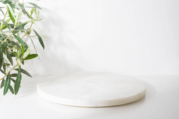 istock White marble podium for product presentation with olive tree leaves 1395307267