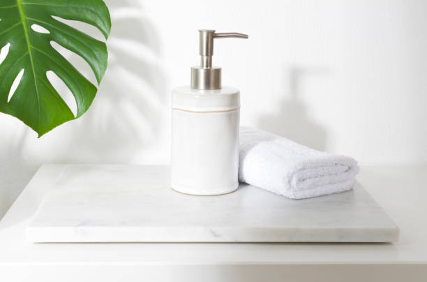 istock Ceramic soap dispenser and folded towel on white marble stand 1395307293