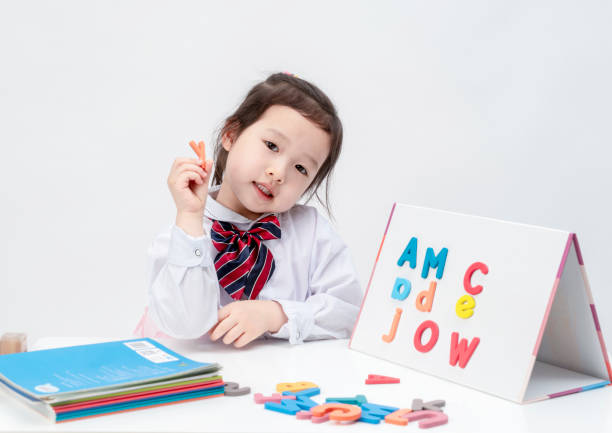 The lovely little girl is learning letters