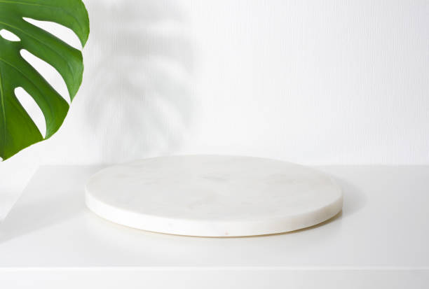 istock White marble podium for product presentation with tropical tree leaves 1395307507
