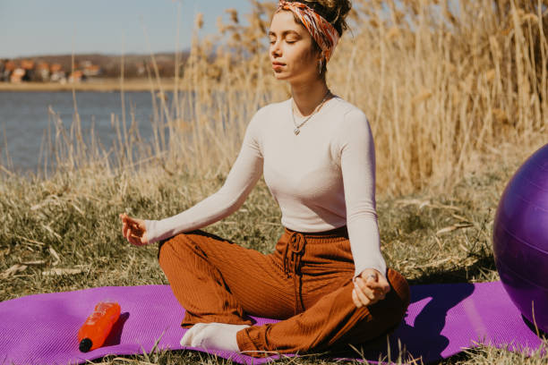 istock Young woman relaxing while meditating in nature 1395308640