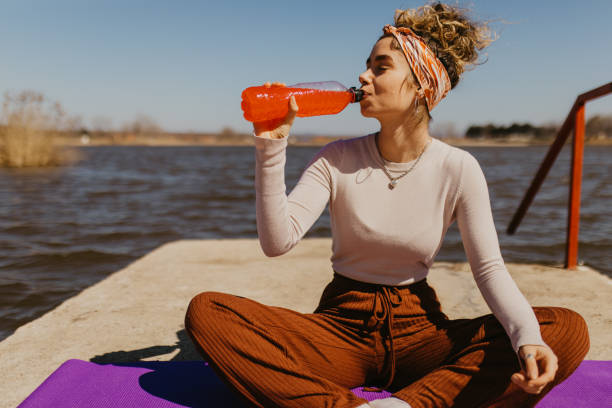Young woman drinking juice while resting from workout stock photo