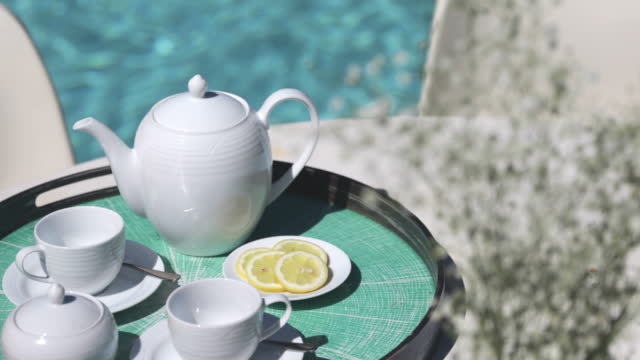 Tea service on tray at sunny poolside