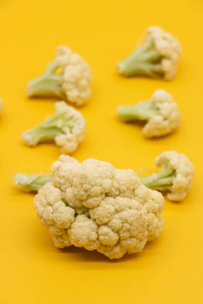 Ripe Cauliflower pieces isolated on yellow background,