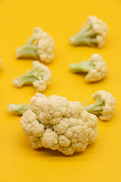 Ripe Cauliflower pieces isolated on yellow background, stock photo