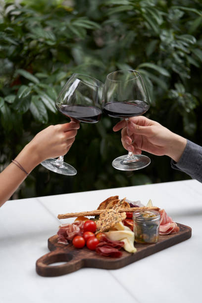 пара с бокалом красного вина в ресторане на открытом воздухе, - antipasto prosciutto italian culture ham стоковые фото и изображения