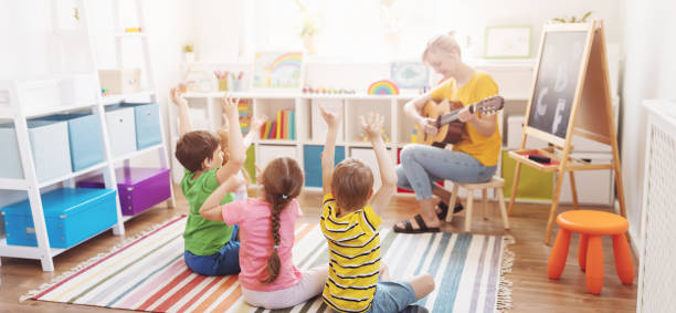 Group of children and teacher in the music class stock photo