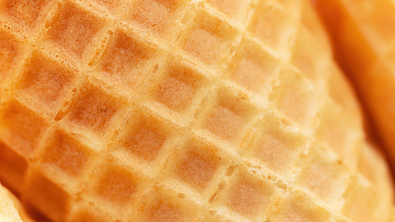 Ice cream waffle cone high resolution macro photography. Texture of crispy waffles close-up with copy space. A waffle cone with a square rough texture.