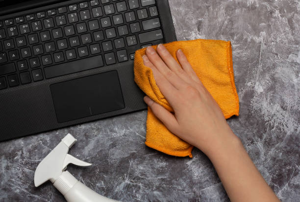 istock Cleaning a laptop keyboard with a rag and cleansing spray bottle 1395314542