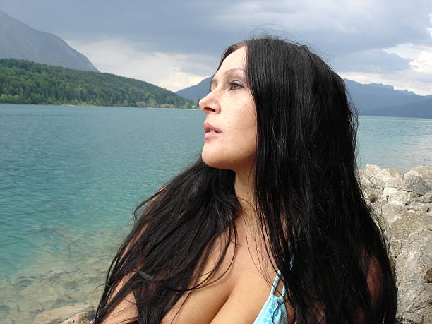 Young Woman sitting on a lake stock photo