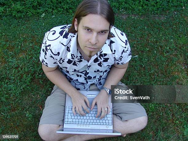 Junger Mann Sitzt Auf Gras Mit Laptop Stockfoto und mehr Bilder von Akademisches Lernen - Akademisches Lernen, Arbeiten, Baum