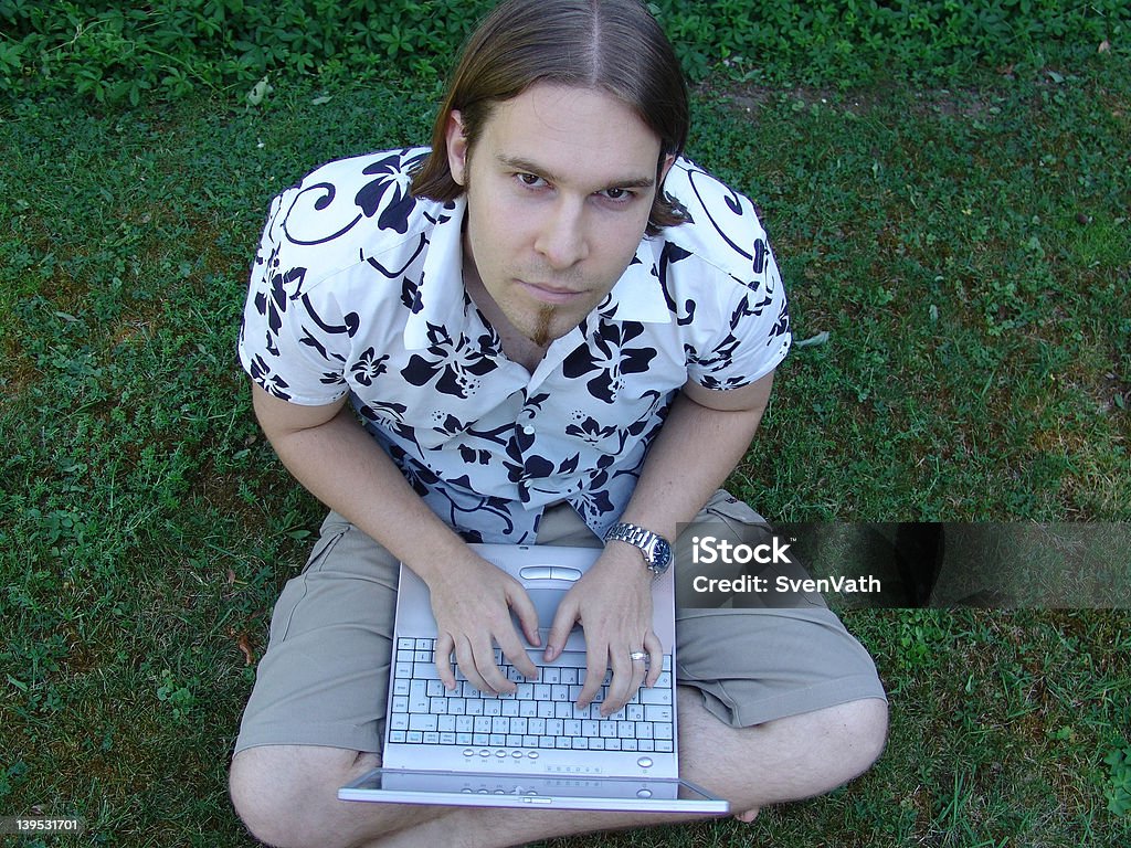 Hombre joven sentada sobre césped con capacidad para computadora portátil - Foto de stock de Adulto libre de derechos