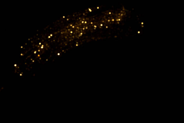 istock Golden blurred bokeh lights on black background 1395319393