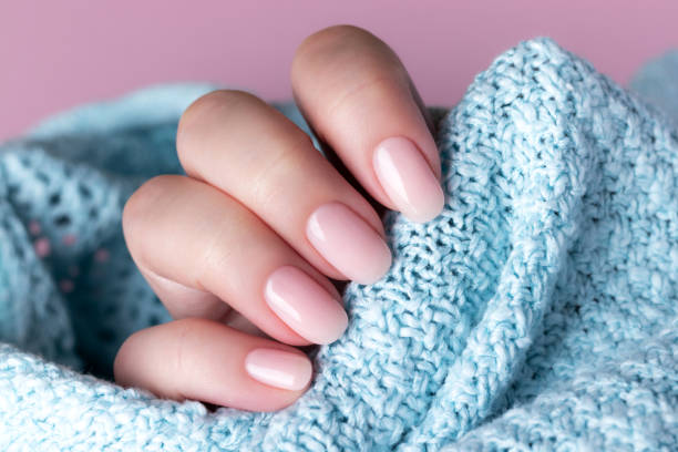 istock Hand in sweater with nude nails 1395319571