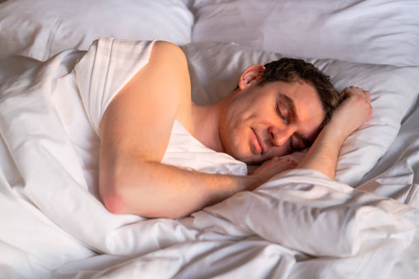 istock Handsome man sleeping in his bed in the sunny morning. 1395320006