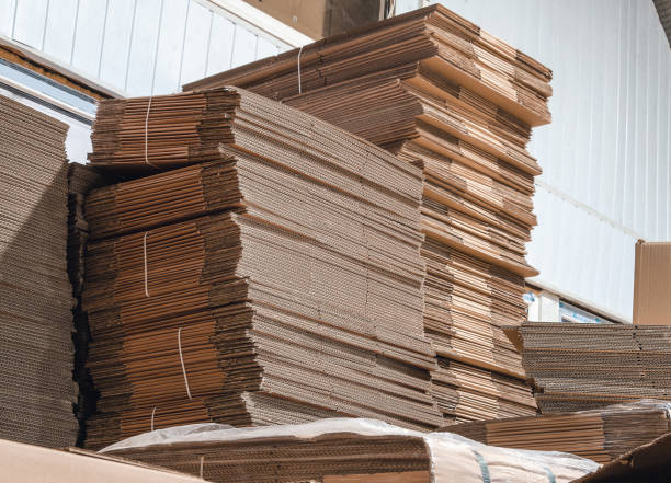 istock Folded cardboard boxes in the warehouse. Stack of flat industrial folding cardboard packing boxes. 1395320928