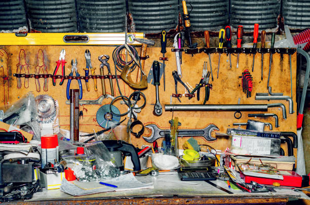 istock Workshop with tools. A collection of various repair tools hanging on the wall above the desktop. 1395320930