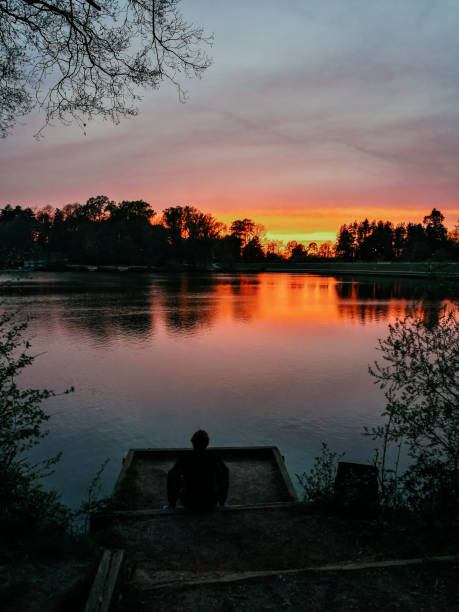 istock Person enjoying peace and solitude by lake at sunset 1395321301