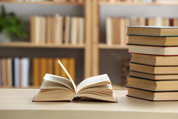 istock Many books on wooden table in library 1395322277