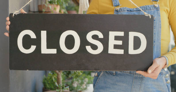 istock Unrecognizable person holding a closed sign at work 1395322597