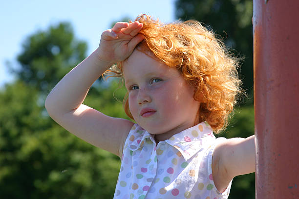 Phoe, it's hot!! Young girl wiping her forehead due to the warmth little redhead girl stock pictures, royalty-free photos & images