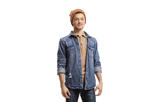 Portrait of a guy in jeans and a woolen hat looking at the camera isolated on white background