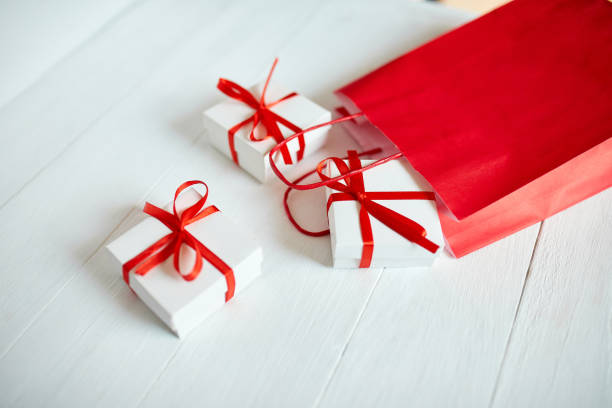 istock Gift boxes out from red paper bag on white background. Romantic Valentines day present, red and white gift box with ribbon, Christmas, Happy Birthday. holidays and celebration concept 1395326197