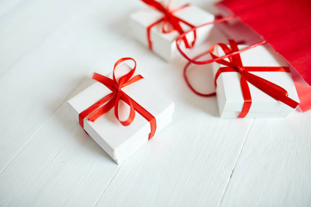 istock Gift boxes out from red paper bag on white background. Romantic Valentines day present, red and white gift box with ribbon, Christmas, Happy Birthday. holidays and celebration concept 1395326208