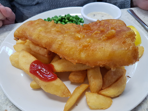 Typically british , take away fish, chips and peas with tomato ketchup