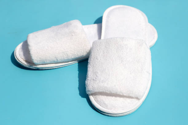 istock Hotel slippers on blue background. 1395329324