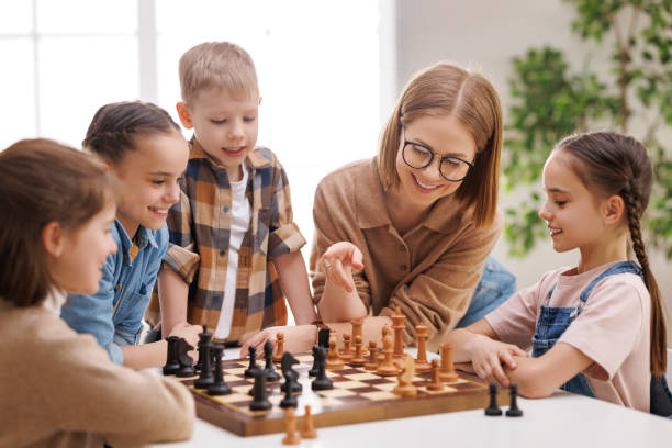 istock Woman teaching kids to play chess 1395329525