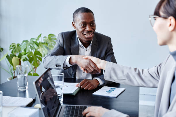 istock Black Executive Shaking Hands with Colleague at Meeting 1395329814