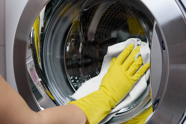 istock In bathroom cleaner wipes a steel-colored washing machine drum with a white rag 1395331459