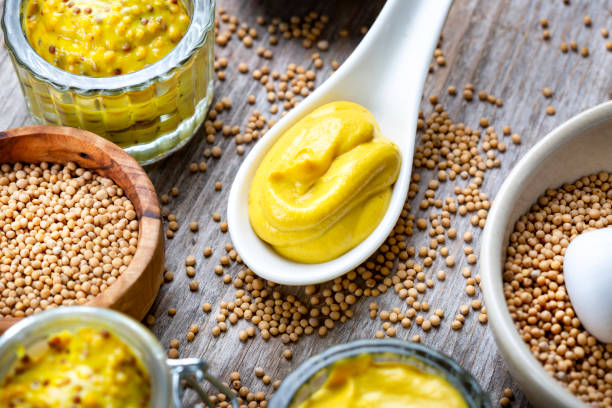 istock Different types of mustard and mustard seeds on a rustic wooden board 1395333164