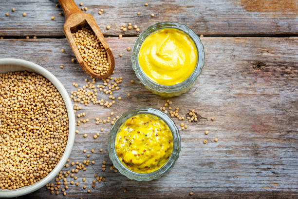 istock Different types of mustard and mustard seeds on a rustic wooden board 1395333180