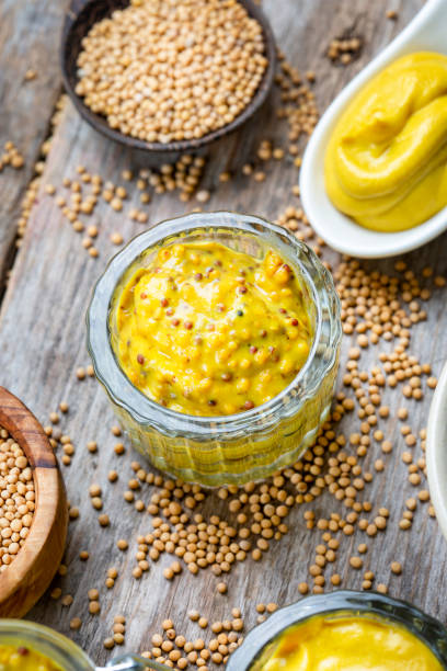 istock Different types of mustard and mustard seeds on a rustic wooden board 1395333187