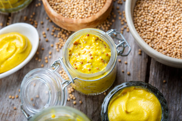 istock Different types of mustard and mustard seeds on a rustic wooden board 1395333191