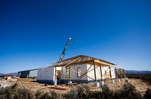 Using a crane to set the trusses on an ICF (Insulated Concrete Form) house under construction.