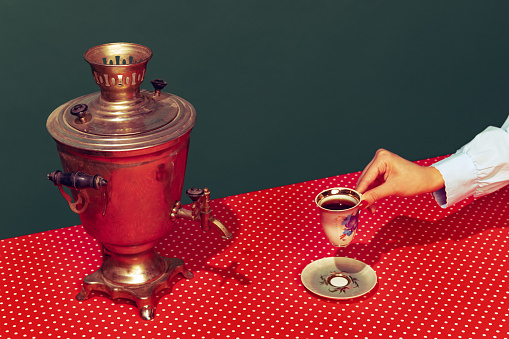 Colorful bright image of old-fashioned kettle called samovar isolated over dark green background. Tea party. Concept of retro pop art, vintage things, mix old and modernity. Copy space for ad