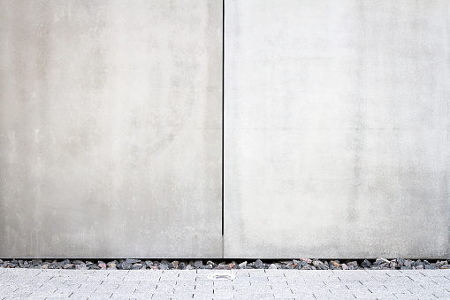 Modern large concrete cement tile wall and a sidewalk