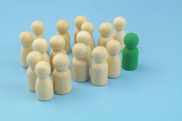 istock Colored figure as leader with many common wooden people figures. 1395338471