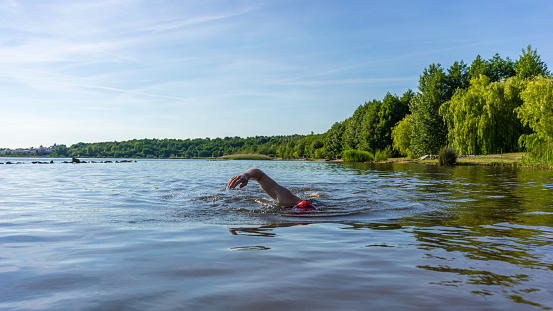 Woman swimming in a lake on a summer day