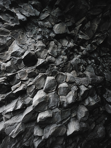 Out of this world volcanic rock formation background. Textured and dark.