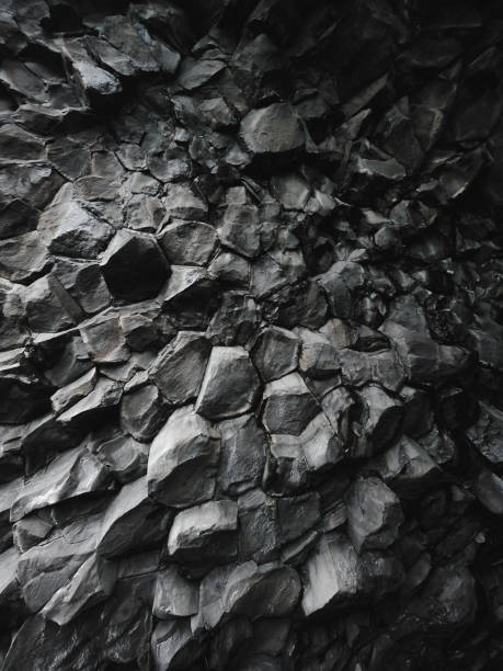 The Black Sand Beach Reynisfjara Rock Formation Out of this world volcanic rock formation background. Textured and dark. igneous rock stock pictures, royalty-free photos & images