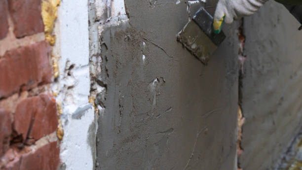 istock Plastering cement at wall for renovation house. Plasterer smoothing plaster on wall. Putty brick wall background 1395343074